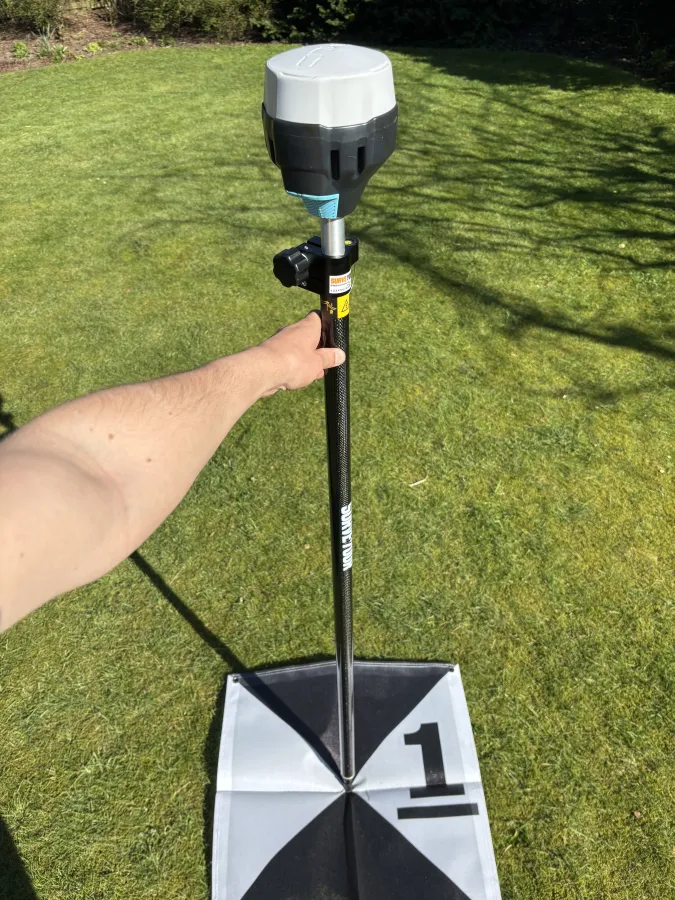 GNSS-meetstok boven een grondcontrolepunt tijdens het inmeten van een meetlocatie