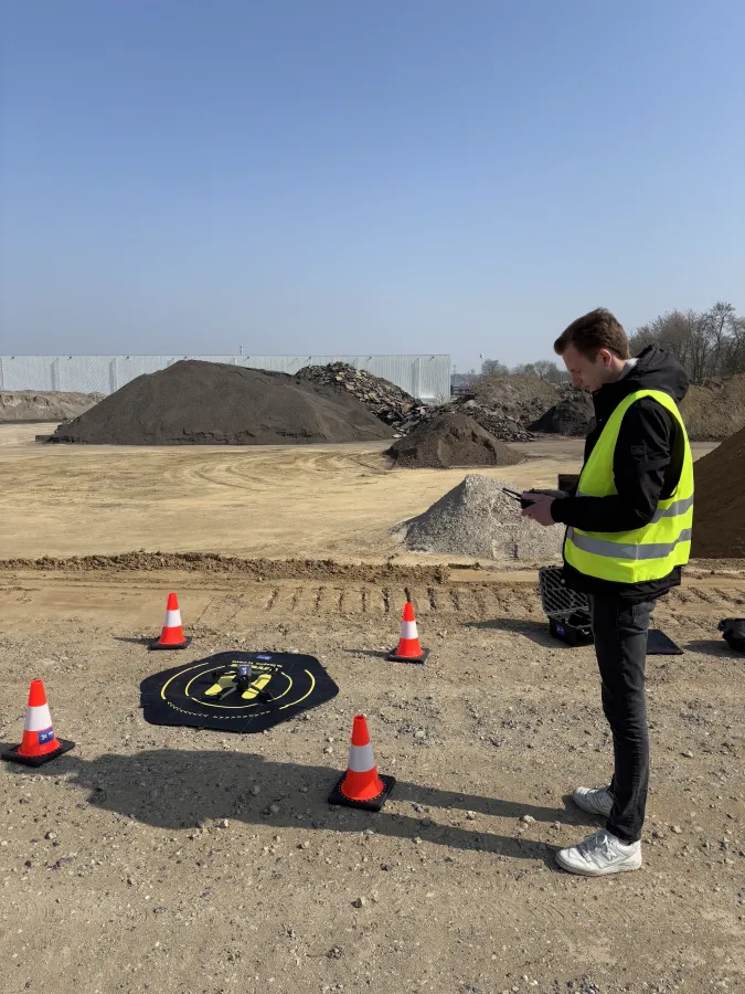 MRR Drones-piloot start een automatische dronevlucht vanaf het landingsplatform op een grondverzetlocatie