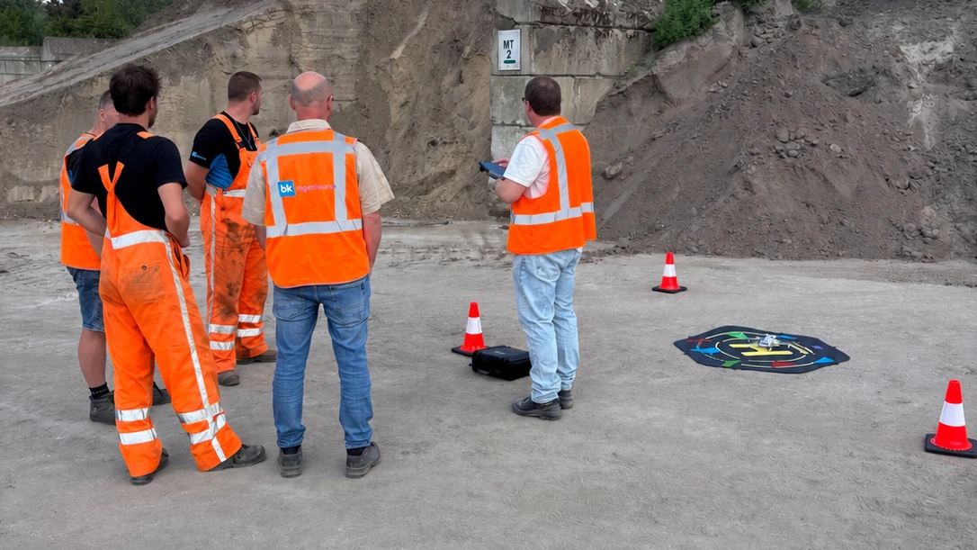 Veldwerkers van BK Ingenieurs in hi-vis rond de drone op de landingsplaat tijdens de training op locatie